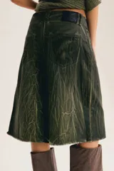Bermuda de denim verde militar con efecto craquelado, corte culotte, tiro medio y ruedo deshilachado por debajo de la rodilla.