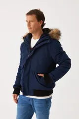 Campera Wrangler de hombre, modelo Teddy, color azul marino con capucha desmontable con borde de piel sintética, cierre frontal con cremallera y botones a presión, bolsillos laterales con solapa y puños y cintura acanalados en negro.