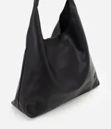 Cartera grande modelo hobo de Satinato, confeccionada en poliuretano color negro, de diseño estructurado con base reforzada, asa única larga y cierre superior con botón a presión.