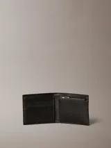 Billetera plegable de cuero negro con diseño de monograma grabado en toda la superficie. Cuenta con monedero interior, compartimento para billetes y múltiples ranuras para tarjetas.