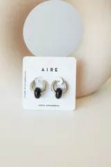 Aros de argolla en acero quirúrgico con dije de piedra natural en tono azul.