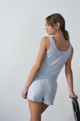 Musculosa celeste con textura acanalada y detalle de puntilla en escote y sisas.