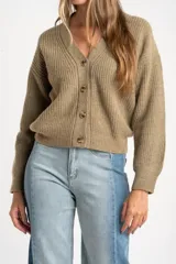 Cardigan de lana color verde oliva, con cuello en V, cierre frontal de botones y diseño de punto acanalado con corte oversize.