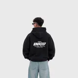 Hoodie negro de corte oversize, con capucha y estampa gráfica blanca en la espalda.