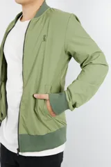 Campera bomber verde de nylon, con cierre frontal y puños acanalados a tono.