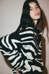 Buzo oversized en punto jacquard con estampado de cebra, cuello redondo y hombros caídos. Presenta terminaciones acanaladas en el cuello, puños y bajo.