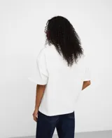 Camiseta relaxed fit blanca de algodón orgánico y reciclado, con cuello redondo en canalé, manga corta con vuelta y hombro caído.