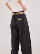 Pantalon de tiro medio-alto con pierna ancha, confeccionado en tela de rayón y poliéster. Presenta bolsillos plaque frontales, costuras a contratono y cierre frontal con botón.
