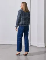 Blazer azul marino de tejido tweed con cuello a la base, apertura central y bolsillos delanteros. Puños con aplique de botones metálicos y terminación desflecada. Forro interno.