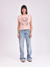 Remera color salmón con cuello redondo y mangas cortas. Estampado en el frente con texto en francés y diseño de palmeras.