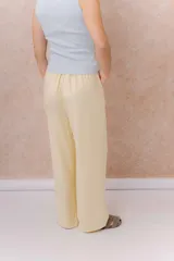 Pantalón amarillo de corte amplio y pierna recta, confeccionado en tela liviana con caída fluida. Cuenta con cintura elastizada, cordón regulable en contraste y bolsillos laterales.