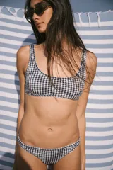 Conjunto de bikini con estampado de cuadrillé azul marino y blanco. Incluye corpiño con escote redondo, breteles anchos y copas desmontables, y bombacha vedetina.
