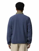 Campera de polar para hombre con cierre frontal completo. Presenta un diseño de bloques de color con cuerpo en azul y detalles en verde oliva en el cuello y la solapa central. Incluye bolsillos laterales con cierre y logo de la marca bordado en el pecho.
