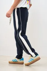 Pantalón de jogging azul marino con cintura elástica, bolsillos laterales y una franja blanca gruesa a lo largo de la pierna.