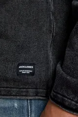 Sweater negro de punto ligero con cuello redondo y mangas largas. Tiene un tratamiento de lavado ácido para un aspecto deslavado y una superficie más suave.