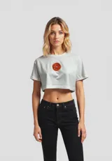 Remera cropped de algodón, color gris claro, con cuello redondo y manga corta doblada. Presenta un estampado frontal de un plátano amarillo.