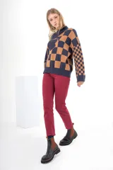 Pantalón de jean color crudo, de tiro alto, corte ajustado y largo cropped. Tiene cierre frontal con botones a la vista.