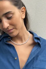 Collar delicado compuesto por perlas barrocas naturales intercaladas con pequeñas cuentas metálicas doradas. Cuenta con cierre de mosquetón y cadena de extensión para ajustar el largo.