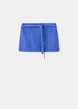 Minifalda azul de tiro bajo con cierre frontal y detalle de lazo para atar en la cintura.