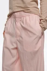 Pantalón jogger negro confeccionado en mezcla de lyocell y algodón, de tiro medio con bolsillos laterales y bajos ajustables mediante cordones elásticos con stoppers.