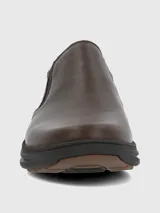Zapato tipo slip-on de cuero marrón con paneles elásticos laterales para un ajuste cómodo y suela de goma oscura con diseño estriado.