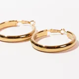 Par de aros tipo argolla grandes, de metal dorado con cierre a presión.
