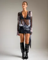 Vestido corto de tul con estampado efecto tie-dye en tonos gris y negro, de manga larga acampanada, escote en V profundo y falda con lazo lateral ajustable.