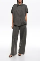 Pantalón de denim color negro con efecto acid wash, corte recto y holgado, de tiro medio con cintura elástica.