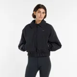 Campera bomber New Balance de corte holgado y diseño minimalista. Presenta cuello camisero, cierre frontal completo, mangas raglán con puños elásticos y cintura elástica. Incluye bolsillos laterales y el logo de la marca bordado en el pecho.