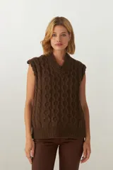 Chaleco de tejido de punto industrial color marrón chocolate, con escote en V y diseño trenzado.