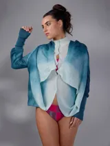 Saco largo de lana merino tejido con diseño jacquard de ramas, de líneas rectas y aberturas laterales, con efecto degradado en tonos azules y blancos, mangas largas con puños entallados y cierre frontal con pequeños botones.