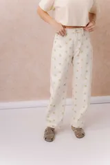 Jean de tiro alto confeccionado en denim color crudo, con estampa de estrellas en tono camel. Presenta calce relajado, pierna recta levemente amplia, costuras verticales delanteras, cinco bolsillos, pasacintos y detalle metálico en la parte posterior.