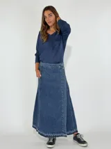 Pollera larga de jean azul con cierre cruzado y botones a la vista.