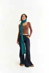 Top de manga larga color marrón, confeccionado en tejido de punto acanalado. Presenta un escote cuadrado y un detalle bordado con las iniciales BG en el centro del pecho.