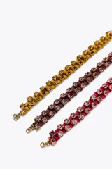 Pack de tres pulseras de tejido a color con aplicación de joyas combinadas a contraste y cierre de mosquetón. Incluye una pulsera fucsia, una púrpura y una amarilla.