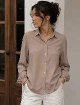 Camisa de diseño clásico con cuello camisero, mangas largas con puño elastizado y cierre de botones al frente.