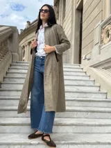 Tapado largo de paño liviano con diseño de cuadros en tonos marrones. Presenta solapas clásicas, bolsillos laterales con detalles en cuero y tajos profundos en los costados.