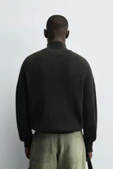 Chaqueta de punto de algodón con textura perlada, corte regular fit, cuello subido y cierre frontal con cremallera. Presenta mangas largas con puños y ruedo en rib.
