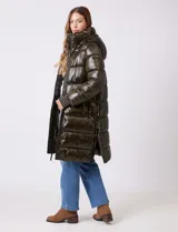 Campera puffer larga de abrigo marca BCBG Maxazria, color beige. Cuenta con capucha desmontable, cuello alto envolvente, cierre frontal bidireccional con solapa de botones a presión, bolsillos laterales, puños internos elastizados y tajos laterales con cierre en el bajo.