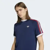 Remera Adidas de manga corta, color azul marino, con cuello redondo blanco. Presenta las tres franjas características de la marca en las mangas en colores rojo, blanco y azul, y el logo del trébol en dorado en el pecho.