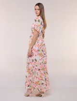 Vestido maxi de gasa con estampado floral en tonos rosados, amarillos y verdes, escote en V cruzado, mangas cortas amplias con abertura y falda larga con niveles fruncidos.
