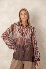 Camisa oversize de gasa con estampado de cadenas en degradé, de corte holgado, cuello camisero y mangas largas abullonadas.
