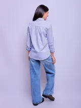 Camisa de vestir entallada a rayas verticales celestes y blancas, de manga larga y cuello clásico.