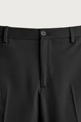 Pantalón de traje slim fit color negro, confeccionado en tejido con viscosa, con bolsillos frontales, bolsillos traseros de doble vivo y raya marcada en las piernas. Cuenta con cierre frontal con cremallera y botón.