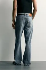 Jeans flare fit de hombre confeccionados en denim de algodón color azul con efecto lavado y roturas. Presentan diseño de cinco bolsillos, efecto salpicaduras de pintura en toda la prenda y bajo con acabado irregular.