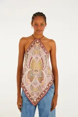 Top halter de viscosa con estampado tipo pañuelo en tonos rosados, bordó y beige con detalles florales y geométricos. Presenta corte en punta y tirantes finos para anudar al cuello.