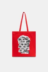 Bolsa tipo shopper de algodón en color rojo, con estampado frontal de collage fotográfico inspirado en películas de Almodóvar. Cuenta con dos asas largas para llevar al hombro.