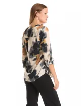 Blusa de gasa con estampado floral en tonos blanco y negro, cuello a la base con escote en V y cierre frontal parcial con botones. Presenta mangas tres cuartos con puños rectos.