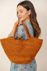 Bolso shopper de mano y hombro tejido a crochet en color naranja, de diseño amplio y asas cortas.