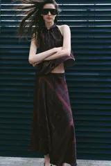 Falda midi de tiro medio, con estampado paisley en tonos bordó y dorado, y detalle de cinturón confeccionado en el mismo tejido.